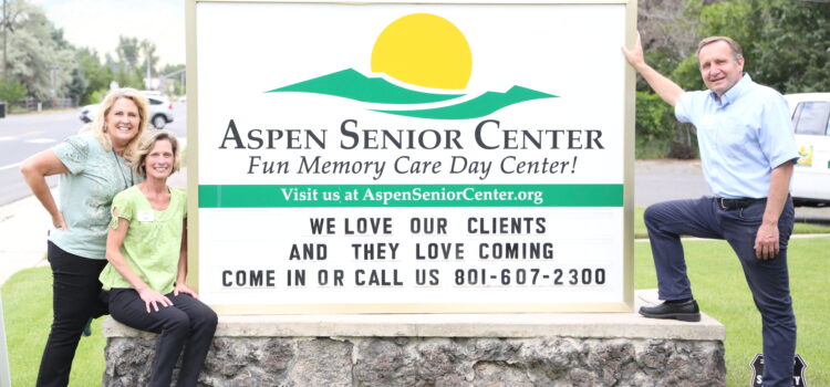 Gary, Julie, and Pam by the Aspen Senior Day Center sign.